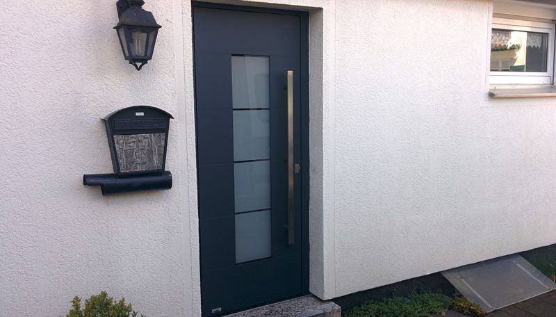 dunkelblaue Tür von Außen gesehen mit vertikalem Milchglasfenster Einsatz mittig
