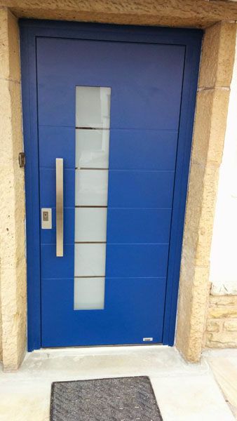 Nahaufnahme der blauen Tür mit Holzrahmen in hellem Holz